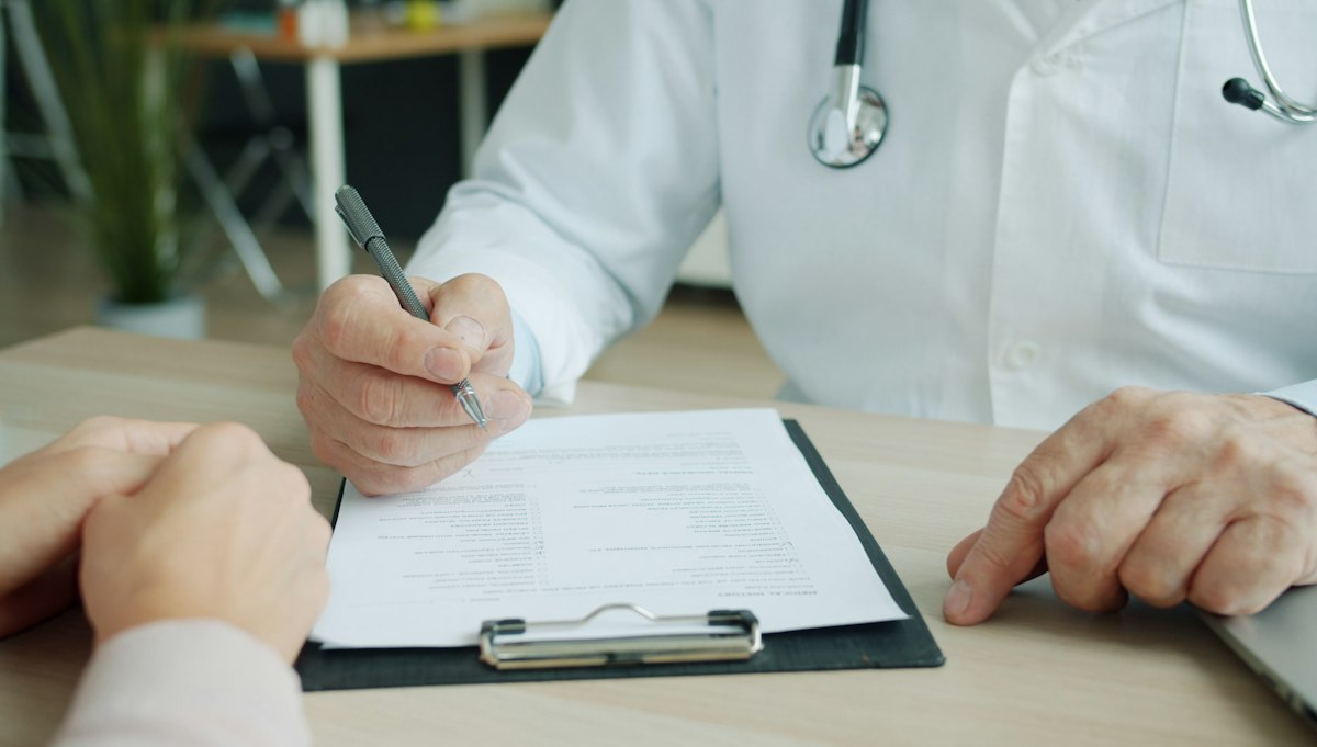 Médico preenchendo formulário com paciente