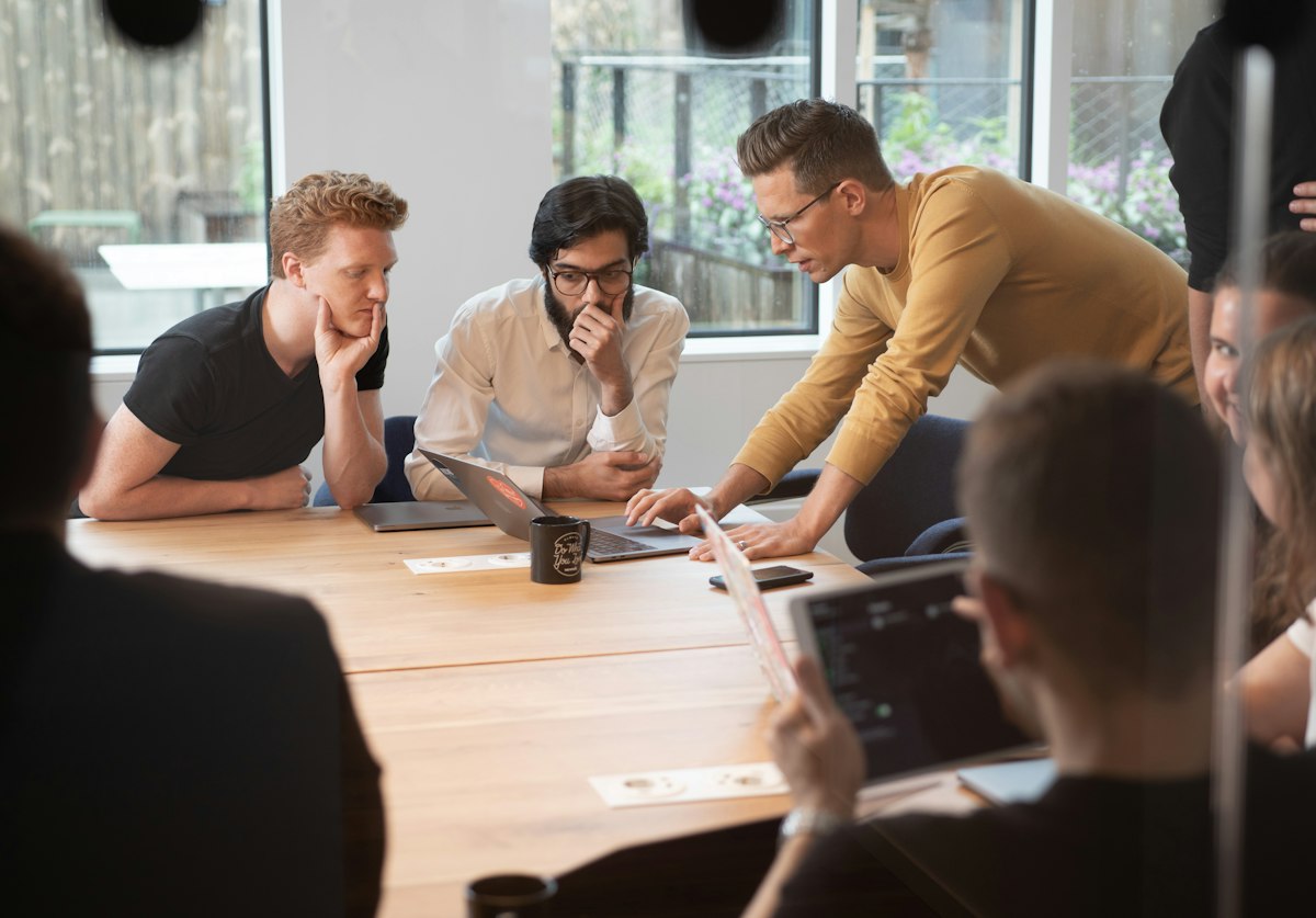 Equipe debruçada sobre a mesa de trabalho