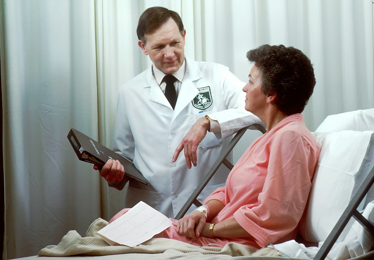 Médico conversando com paciente no quarto