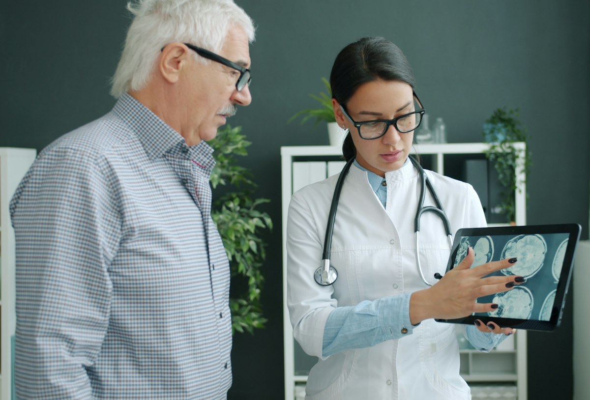 Médica mostrando tablet a paciente