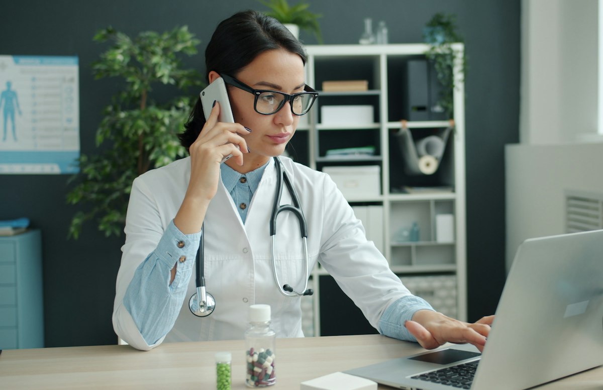 Médica ao telefone no consultório