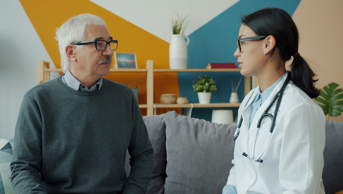 Médica conversando com paciente idoso