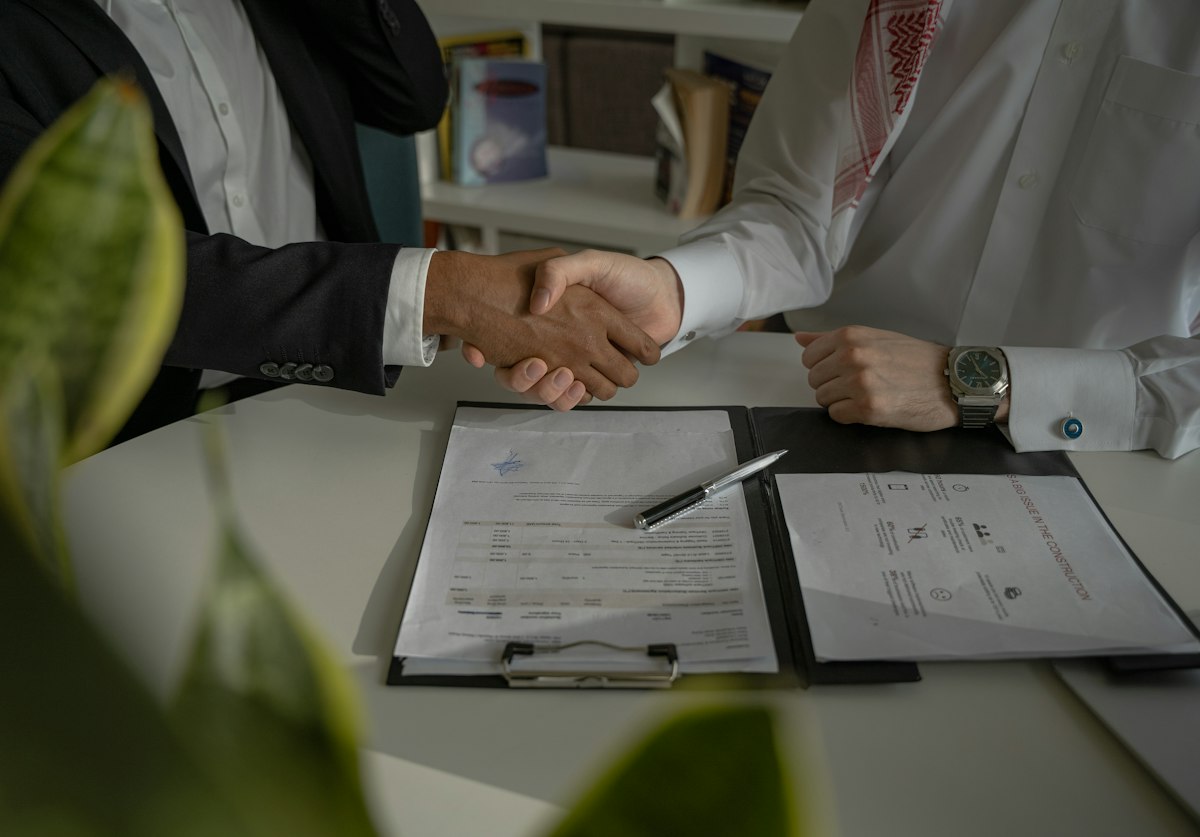 Aperto de mãos sobre contrato na mesa