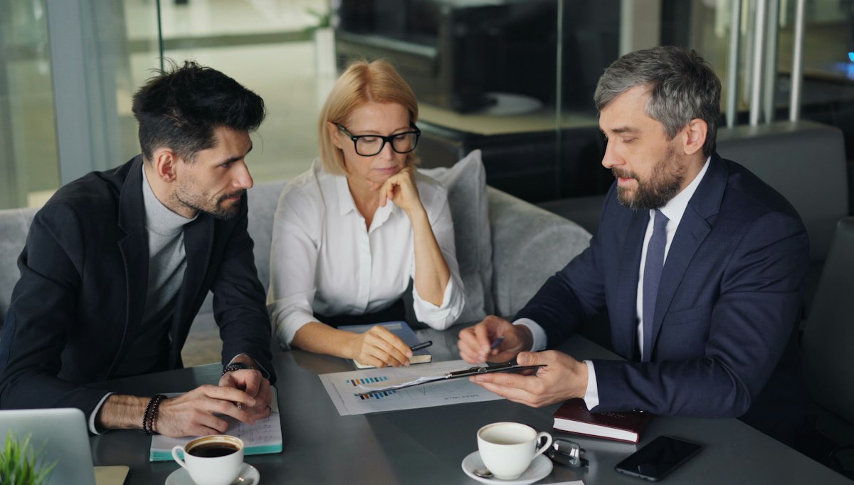 Três executivos analisando documento