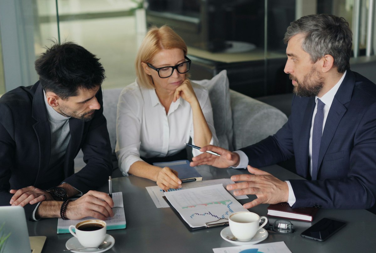 Executivos em reunião com café na mesa